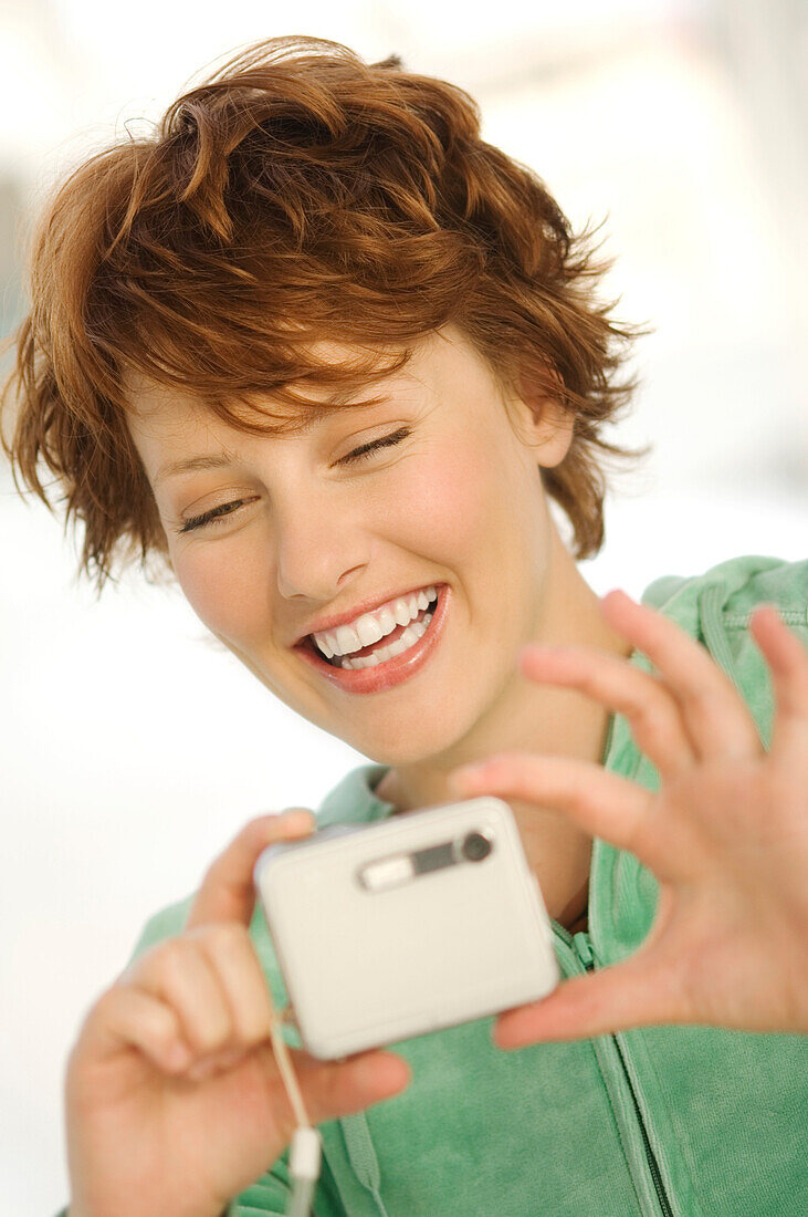 Portrait of a young woman using digital camera