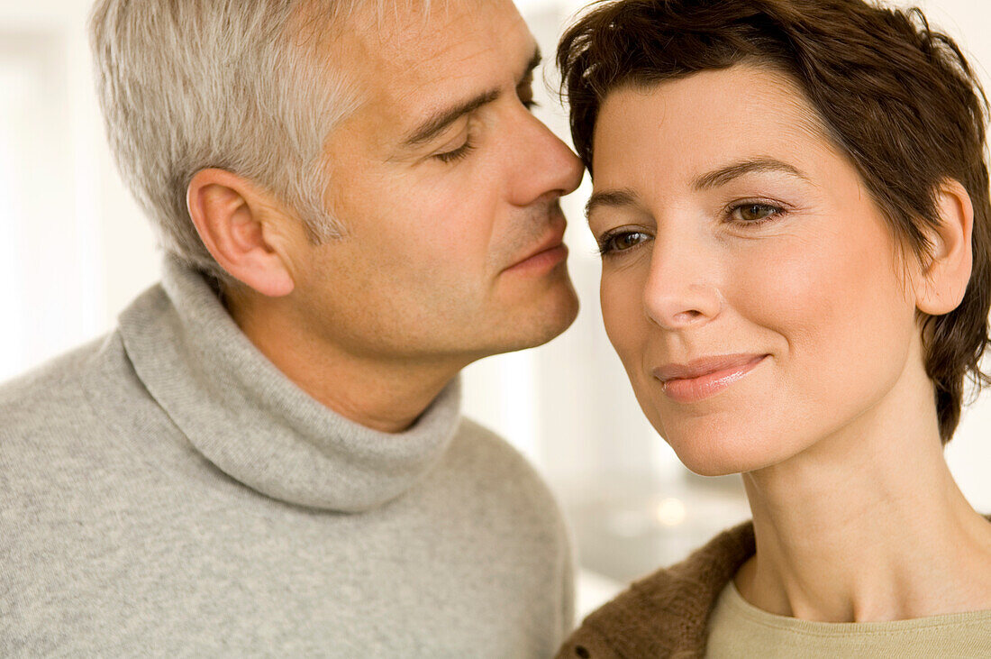 Close-up of a mature man and a mid adult woman romancing