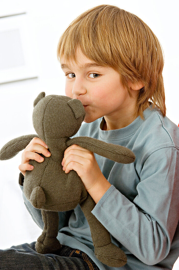 Portrait of a boy kissing a teddy bear