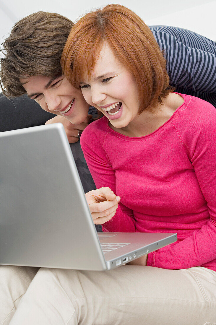 Close-up of two young women and a teenage boy looking at a laptop