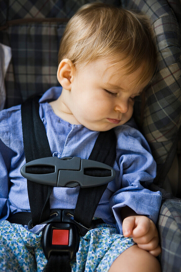 Baby boy sleeping in a baby seat