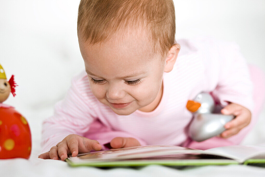 Baby girl looking at a picture book