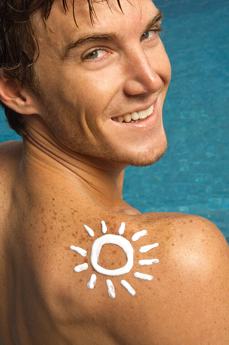 Man with sun shape on his shoulder at the poolside