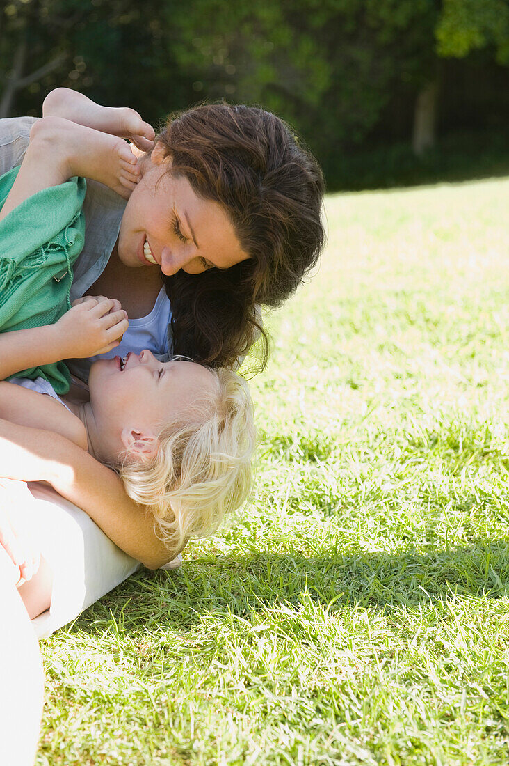 Woman playing with her daughter in a lawn
