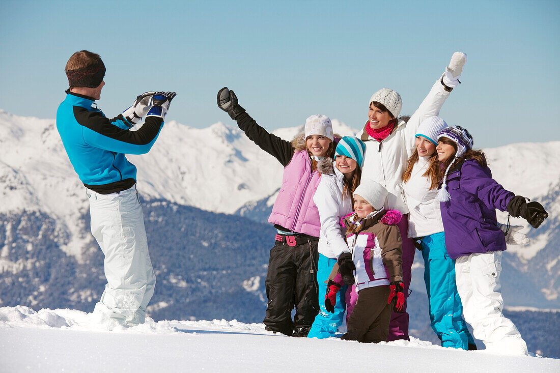 Man taking picture of family in snow