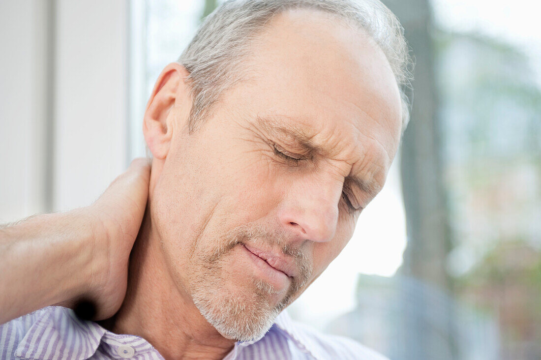 Close-up of a man rubbing his neck