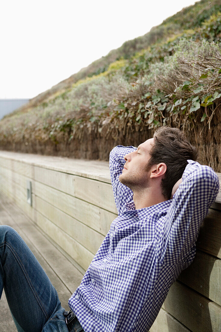 Man resting on a boardwalk