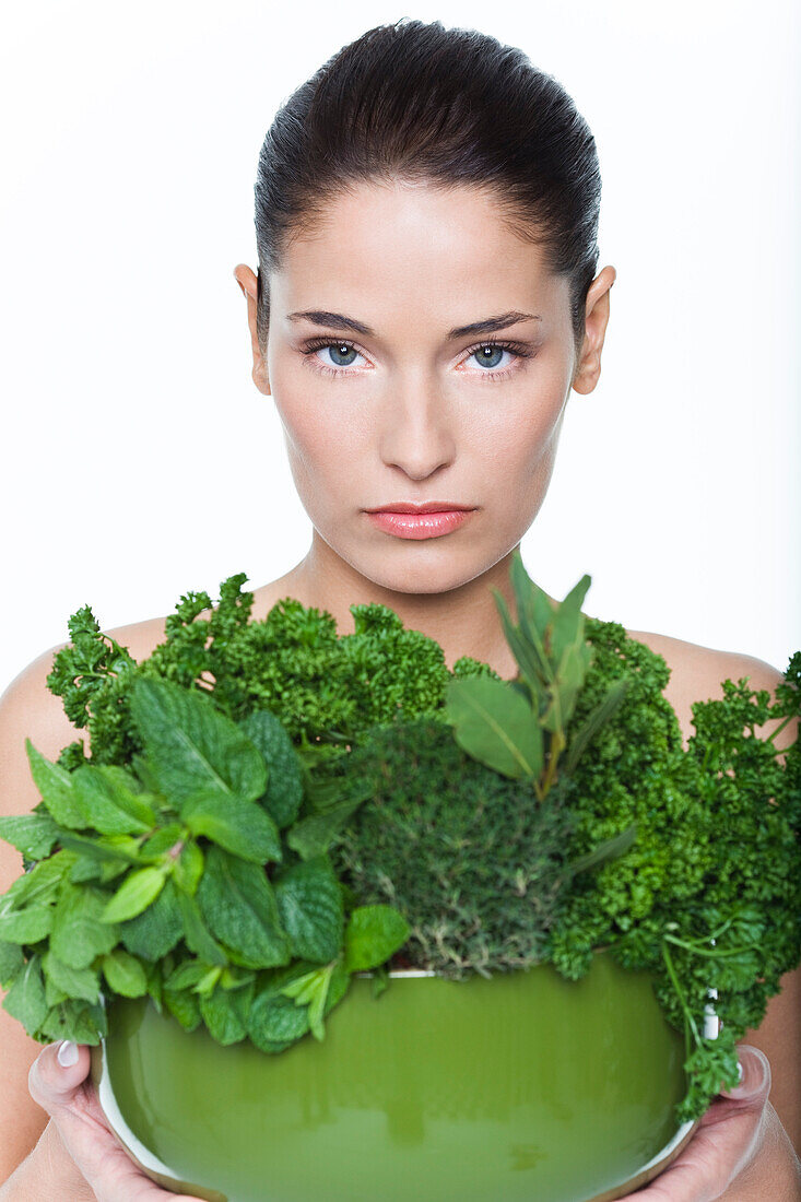 Young woman holding fresh herbs