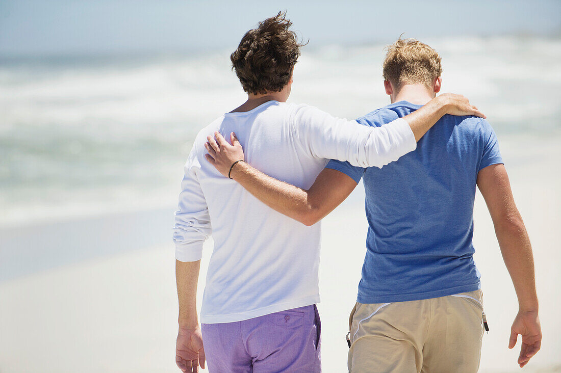 Rear view of two men walking with their arms around each other