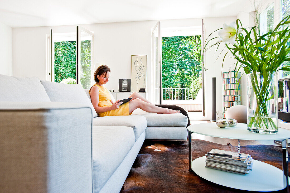 Women using an iPad while sitting on a sofa, Hamburg, Germany