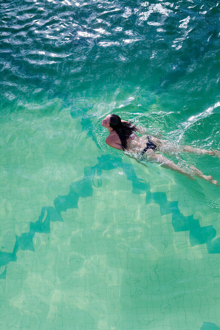 Woman enjoys swim in pool aboard cruise ship MS Astor (Transocean Kreuzfahrten) MR, Baltic Sea, near Denmark