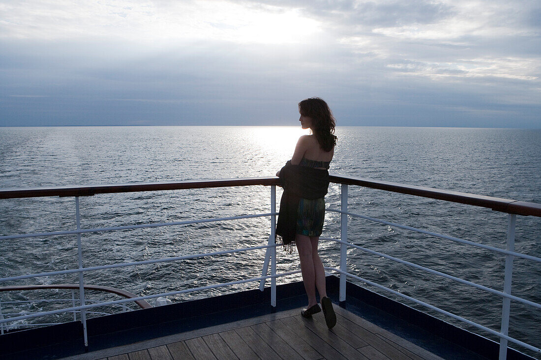 Woman stands at railing aboard cruise ship MS Astor, Transocean Kreuzfahrten, MR, near Kiel, Schleswig-Holstein, Germany