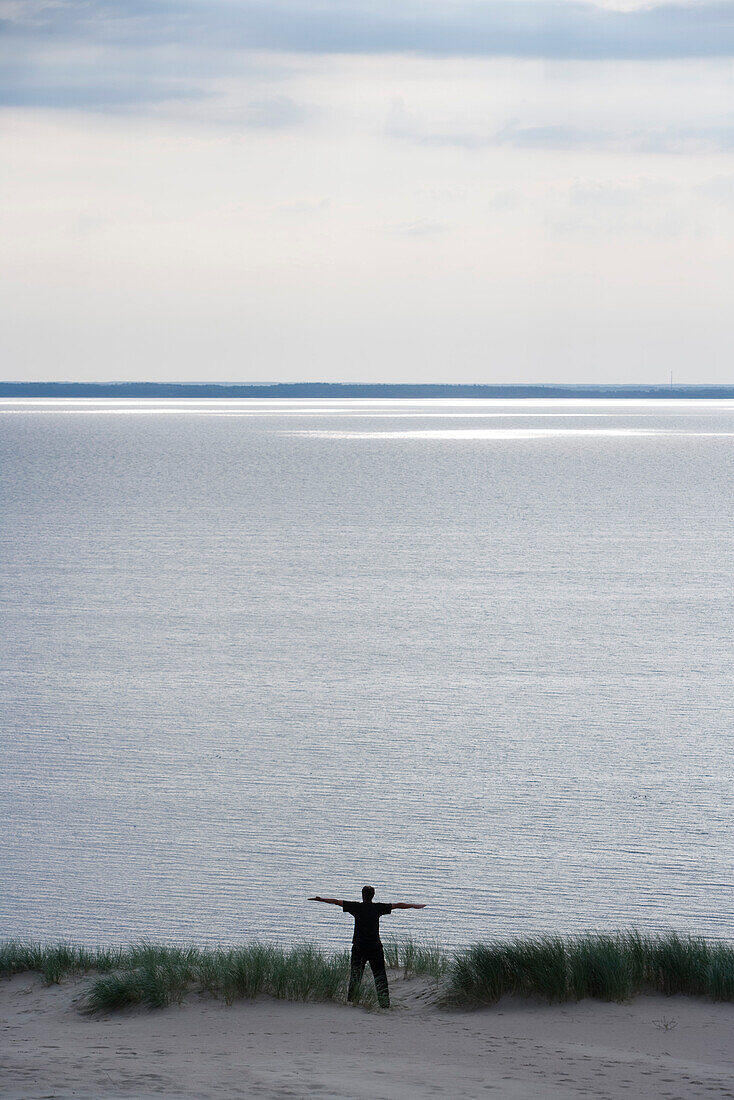 Mann übt Joga auf Düne mit Blick auf Meer, Kurische Nehrung, nahe Klaipeda, Litauen, Europa