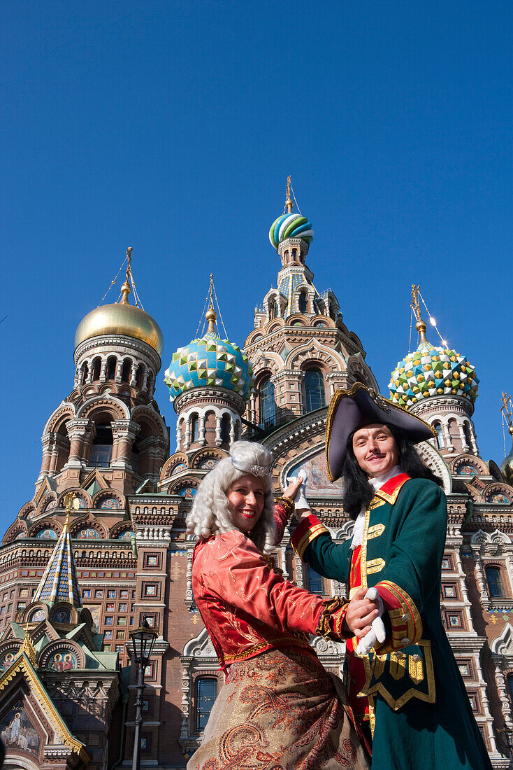 Couple in historic costumes pose as Empress and Tsar in front of Church of the Savior on Spilled Blood, Church of the Resurrection, St. Petersburg, Russia