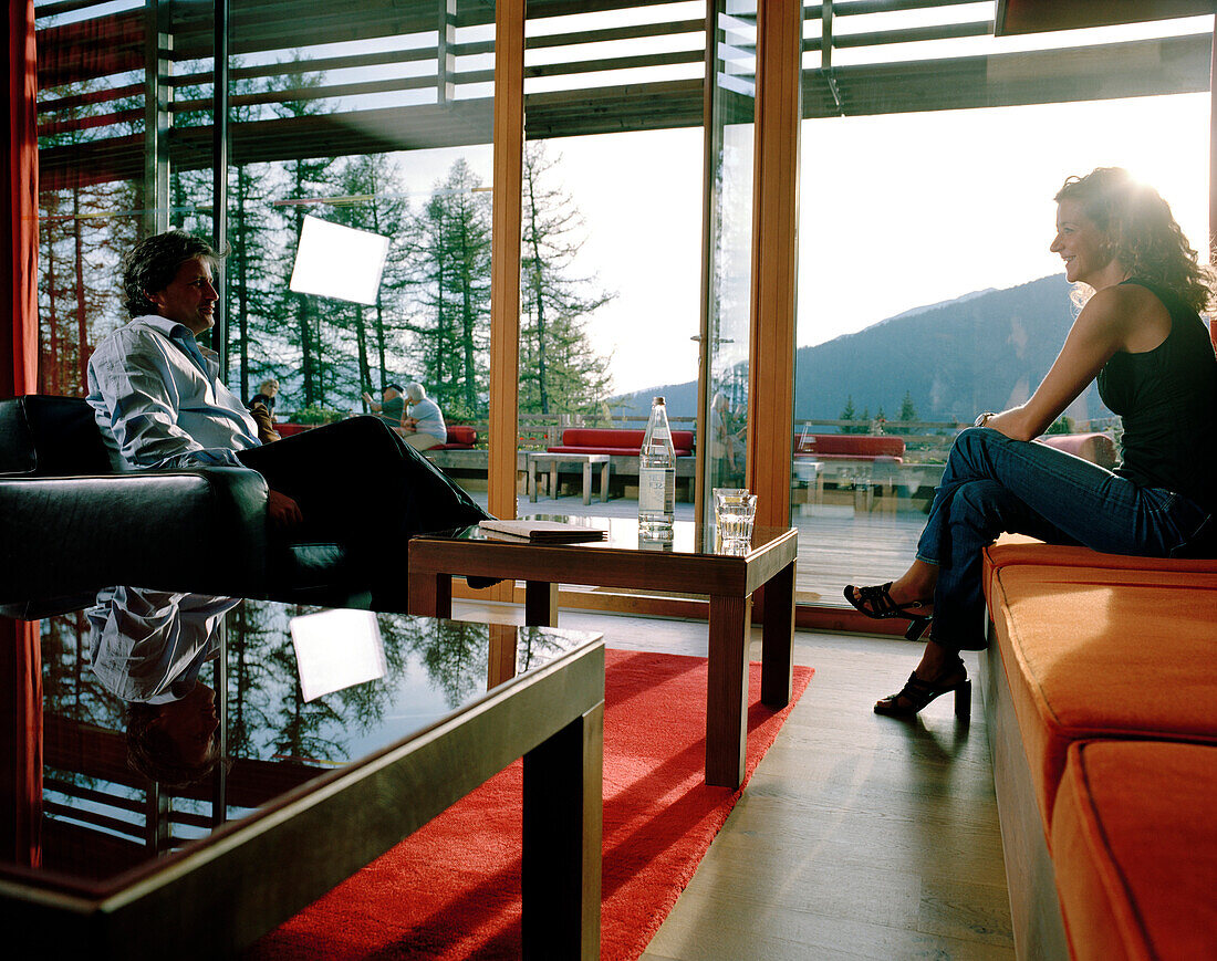 Couple in piazza lounge, Vigilius Mountain Resort, Vigiljoch, Lana, Trentino-Alto Adige/Suedtirol, Italy