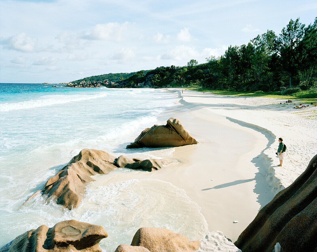 Frau am Strand Petite Anse, südostliches La Digue, La Digue and Inner Islands, Republik Seychellen, Indischer Ozean