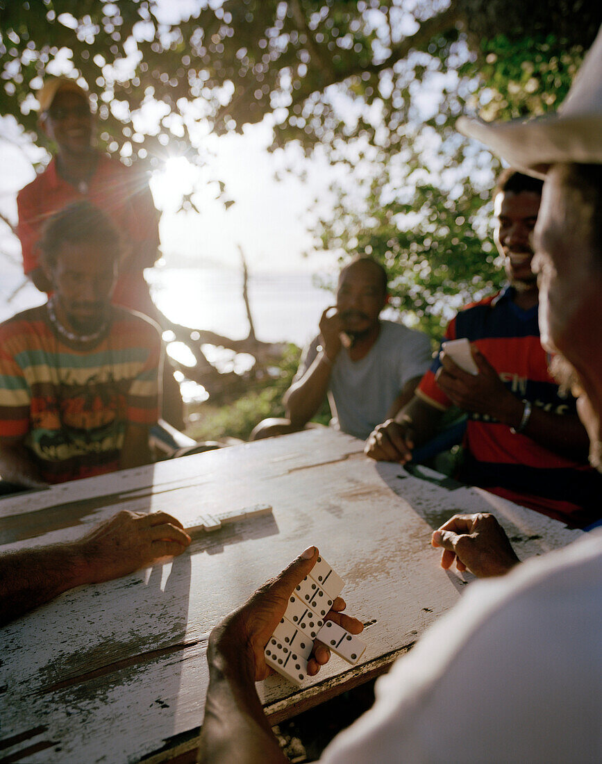 Männer spielen abends Domino am Strand, La Passe, La Digue, La Digue and Inner Islands, Republik Seychellen, Indischer Ozean