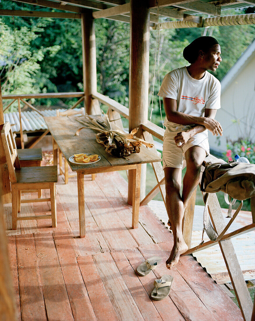 Naturführer und Schmuckhersteller Silvin Fanchette auf der Terrasse seines inseltypischen alten Hauses in La Passe, La Digue and Inner Islands, Republik Seychellen, Indischer Ozean