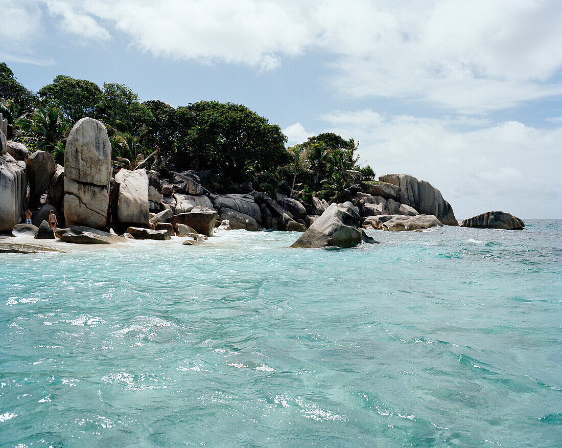 Touristen am Strand der winzigen Insel Coco Island, La Digue and Inner Islands, Republik Seychellen, Indischer Ozean