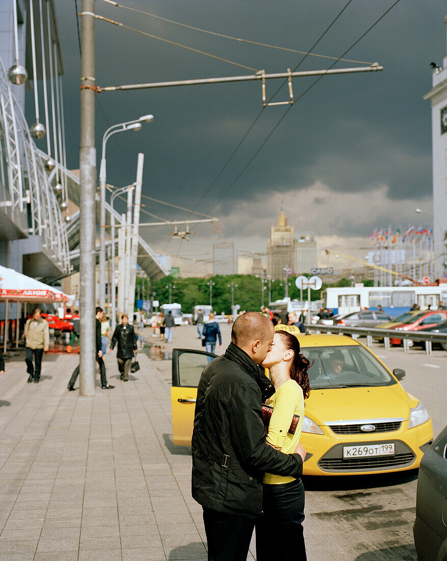 Kissing couple in front of a taxi at Jevropeski Plaza, Moscow, Russia, Europe