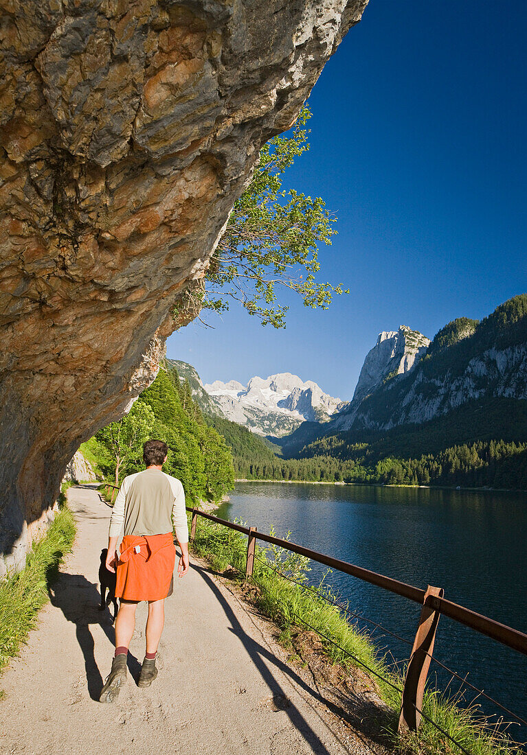 Hiker at lake Gosausee, Gosau, Dachstein mountains, Salzkammergut, Upper Austria, Austria, Europe