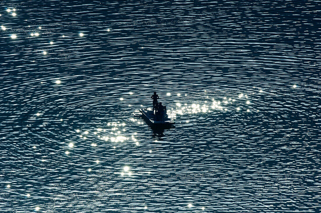 Menschen fahren Tretboot auf dem Kalterer See, Bozen, Südtirol, Alto Adige, Italien, Europa