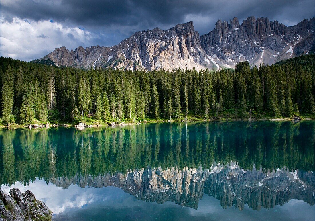 Reflection of forest and mountains on lake Karersee, Latemar, Eggental valley, South Tyrol, Alto Adige, Italy, Europe
