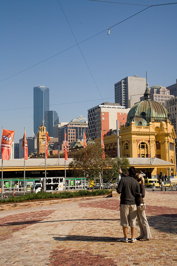 A young couple admire the view from Federation Square, Melbourne, Victoria, Australia