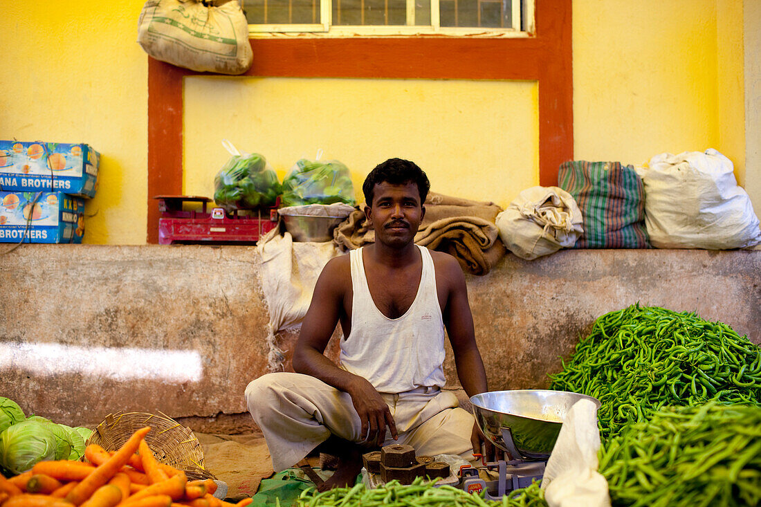 A Vendor Sits Amongst His Fresh Vegetable Produce, Chaudi Market, Chaudi, Goa, India.