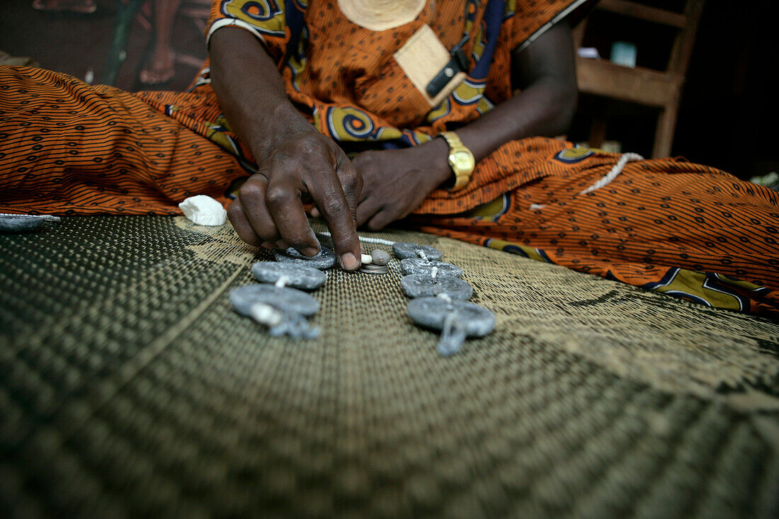 A fortune teller reading the future, Porto Novo, Benin, West Africa.  A Bokonon, or diviner, consults  Fa, a  traditional method of divining / geomancy.