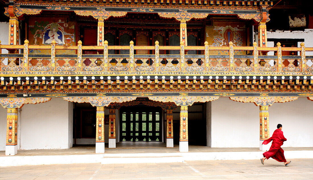 Monk walking in front of dzong, Punakha, Bhutan