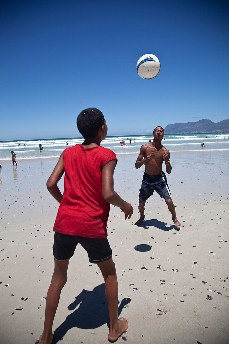 'Local boys playing football on beach, Muizenberg, Cape Town, South Africa'13;&#10;'