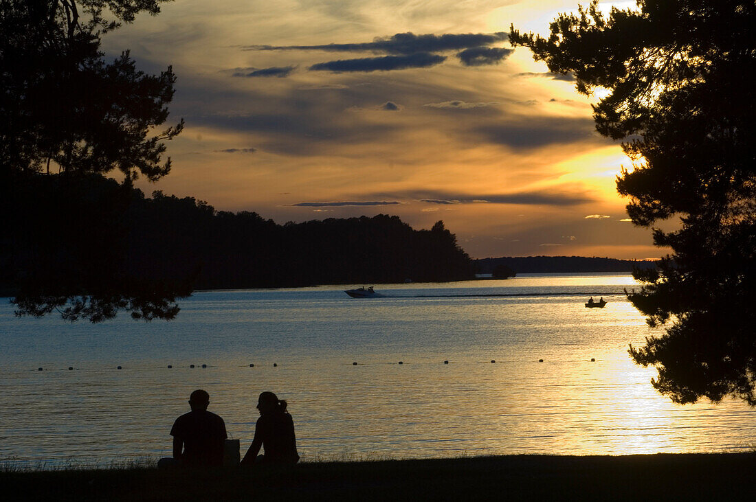 Couple enjoying the sunset over Lake Malaren, Sundbyholm Manor, Eskilstuna Municipality, Sweden.
