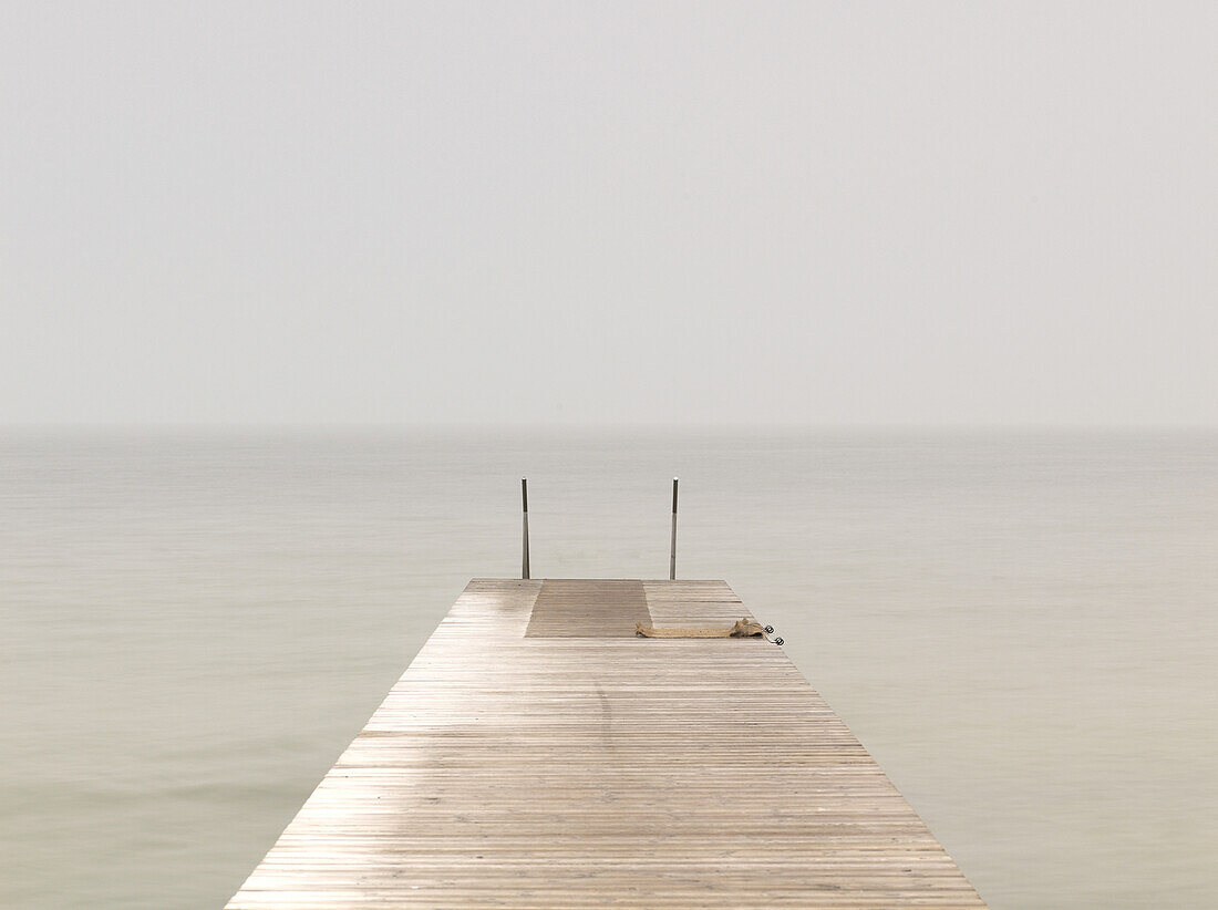 Wooden pier on misty lake at dawn, Sweden