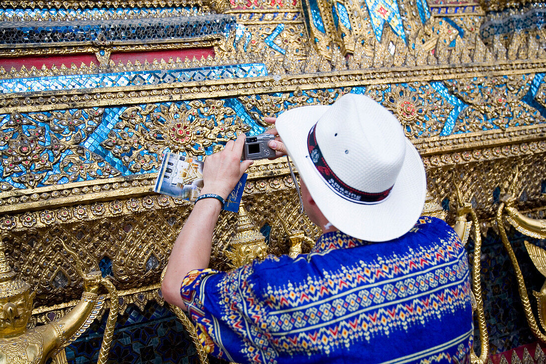 Man taking pictures of bot walls of Wat Phra Kaeo at Grand Palace, Bangkok, Thailand