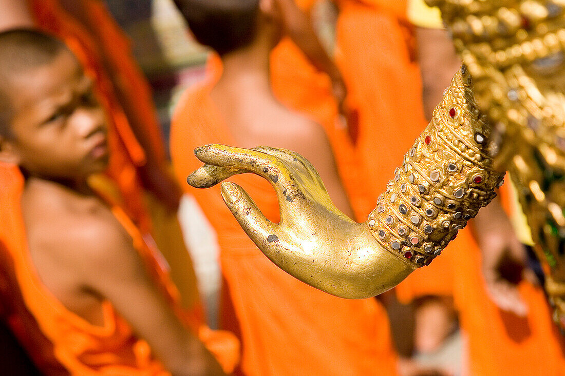 Young monks and hand of gold statue at Grand Palace, Bangkok, Thailand