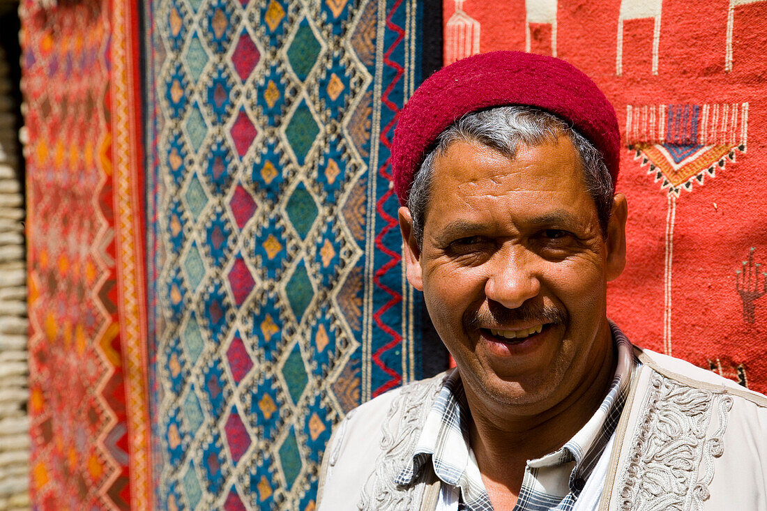 Souvenir shop keeper by carpets, Medina, Tozeur, Tunisia, North Africa