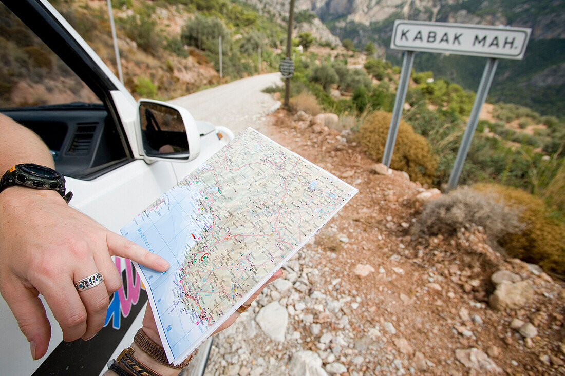Tourist in car checking map, Close Up, Mugla, Turkey.