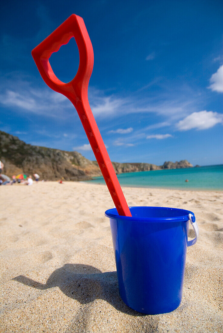 Plastic bucket and spade on Porthcurno beach, low angle view, Cornwall, England