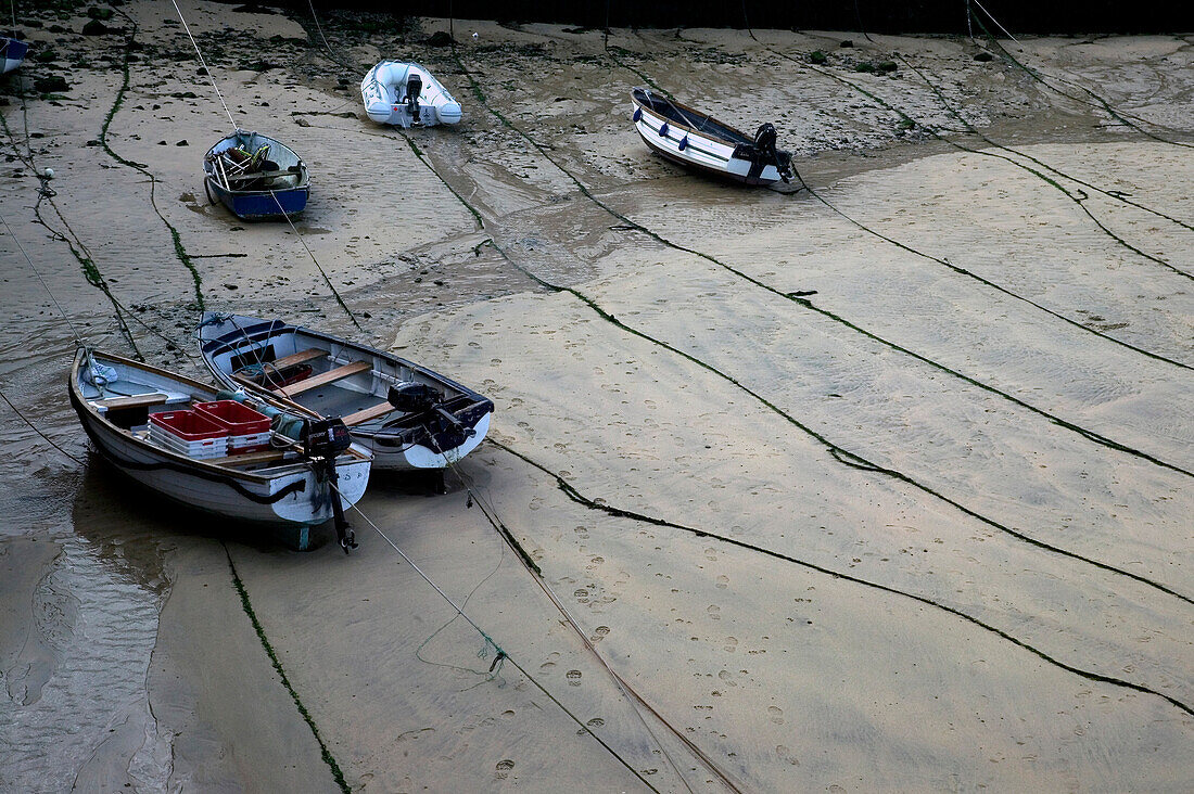 Fishing boats at low tide at St. Ives harbor, Cornwall, England, UK