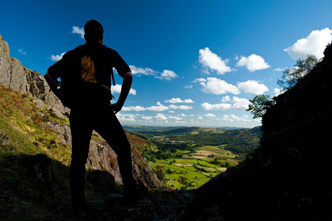 Silhouette of walker looking along Langdale from near Chapel Stile, Lake District, Cumbria, UK.