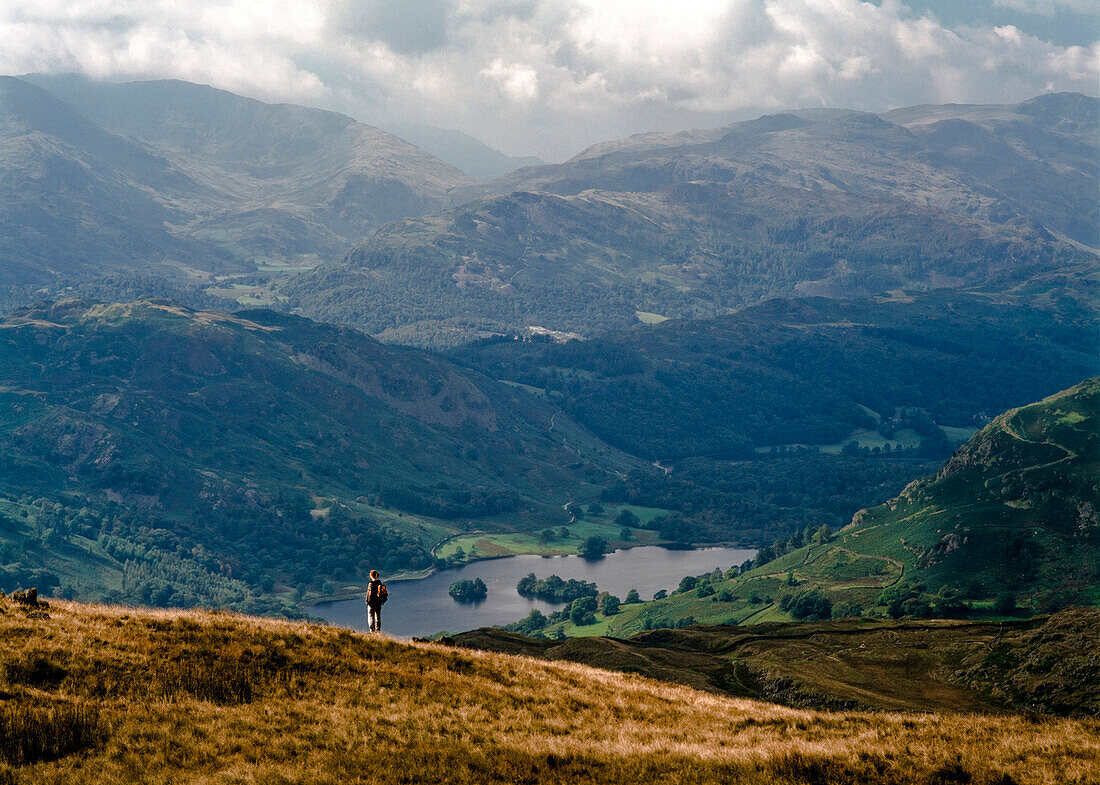 Hiker looking at view at Rydal Water, Lake District, England, UK