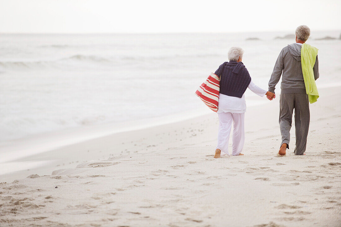 Rear view of a senior couple walking on the beach