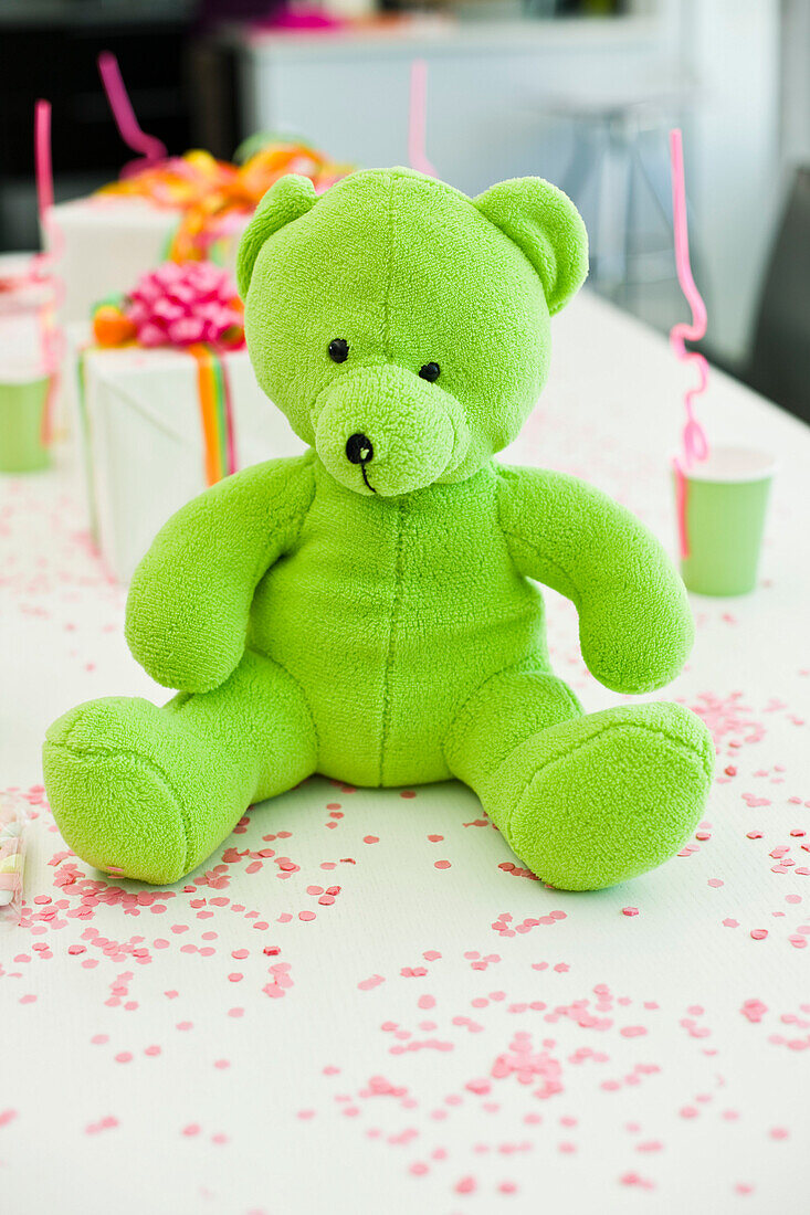 Close-up of a teddy bear with birthday presents on a table