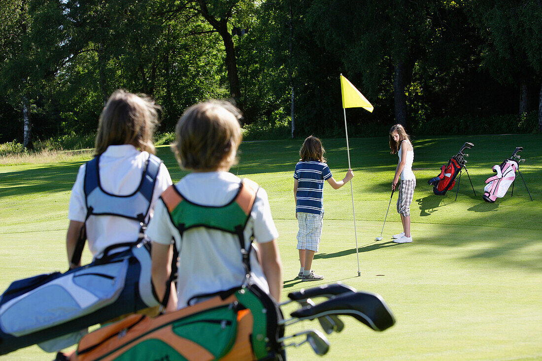 Children playing golf, Bergkramerhof, Bavaria, Germany