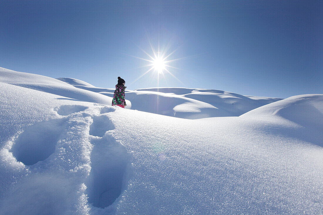 Junges Mädchen stapft durch tiefen Schnee, Klösterle, Arlberggebiet, Österreich