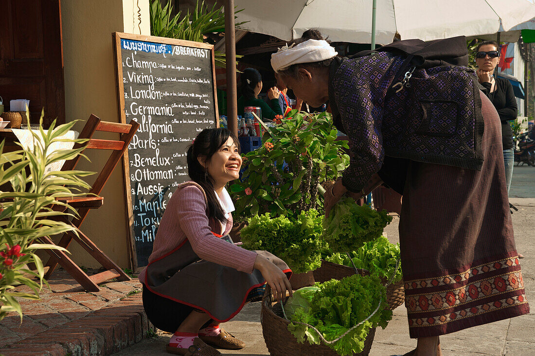 Junge Frau kauft Salat von Bäuerin für ein Restaurant, Luang Prabang, Laos, Südostasien, Asien