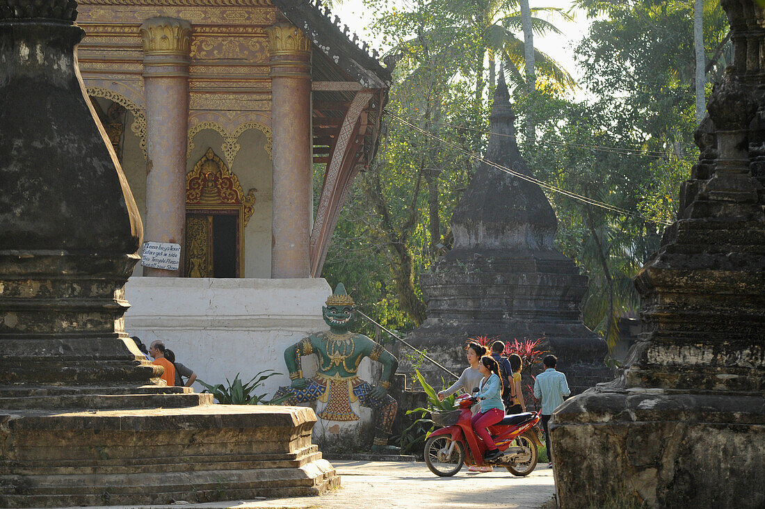 Tempel mit Chedis, Stupas, Frauen auf Moped, Luang Prabang, Laos, Südostasien, Asien