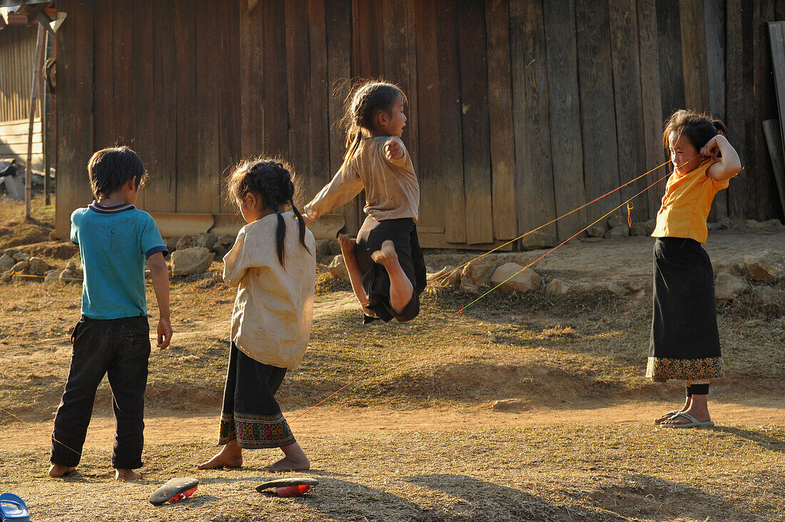 Kinder spielen mit einem Gummiband, Dorf, Ebene der Tonkrüge, Phonsavan, Provinz Xieng Khouang, Laos