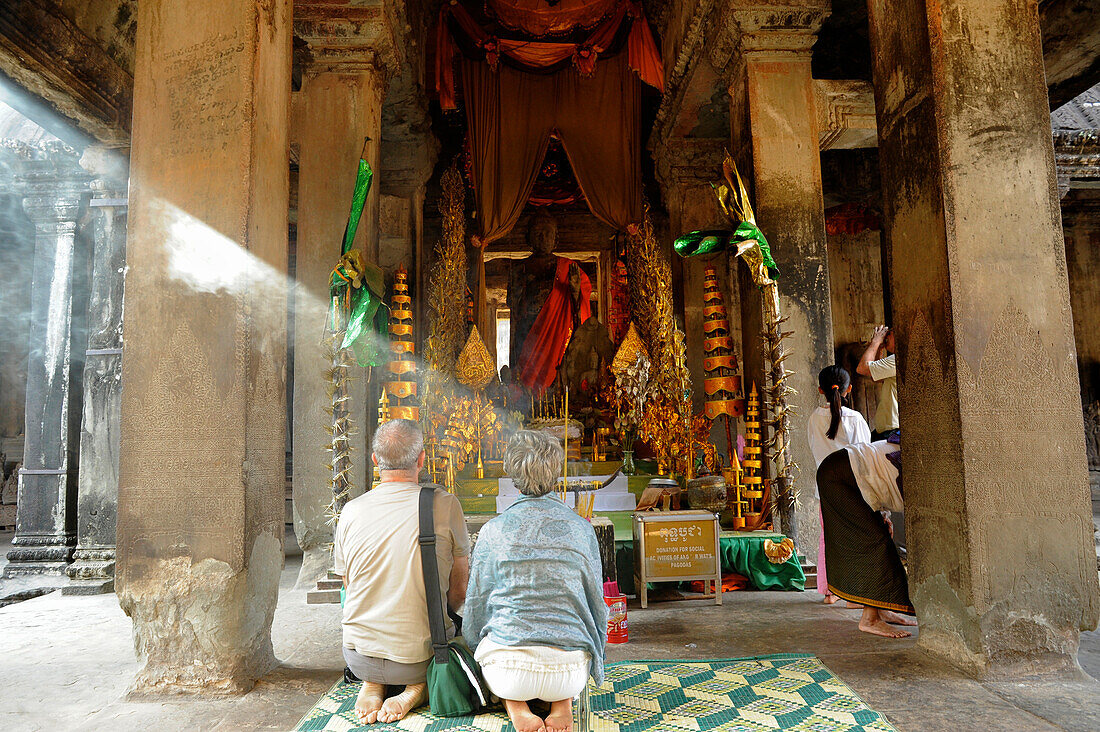 Touristen und kambodschanische Schülerinnen vor einem buddhistischen Altar, Angkor Wat, Angkor, Kambodscha, Asien